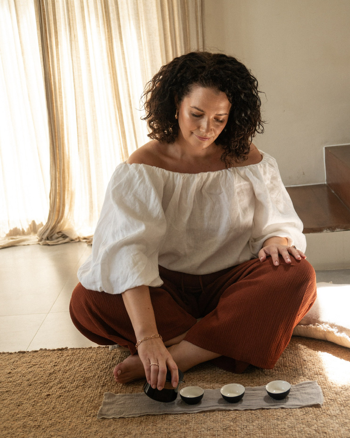 Tara pouring tea in a sunlit room