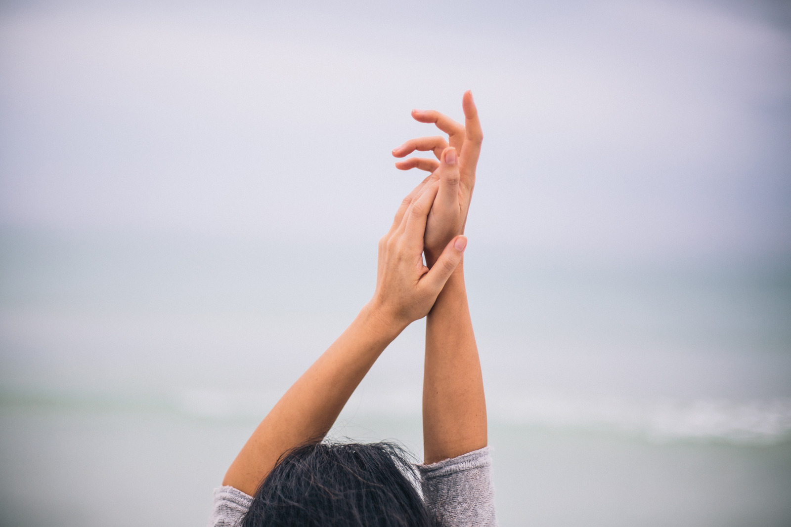 Arms raised gently towards the sky