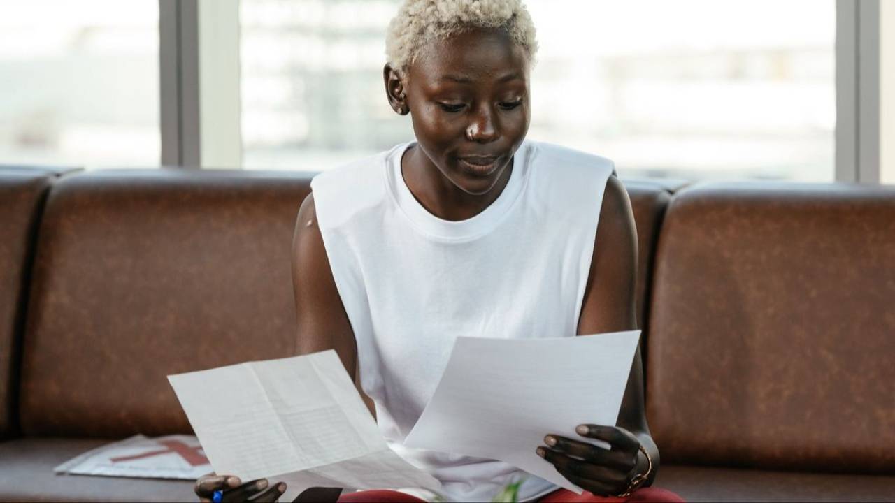 Woman reviewing financial paperwork while seated at a table