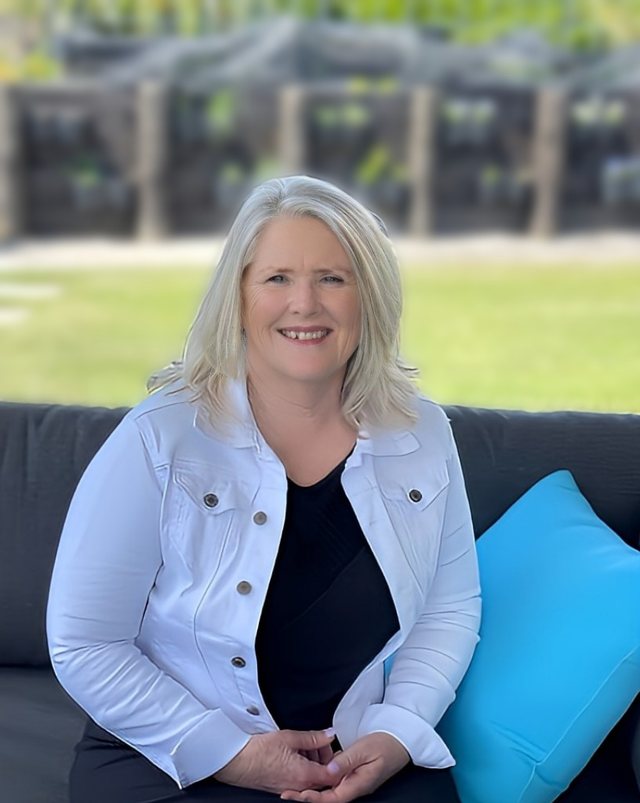 Sandra, founder of Beyond the Chaos, smiling on an outdoor sofa