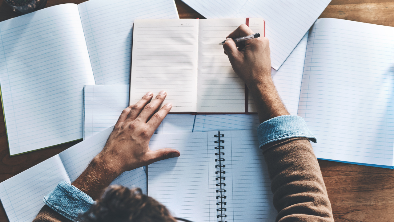 Writing in a notebook among papers