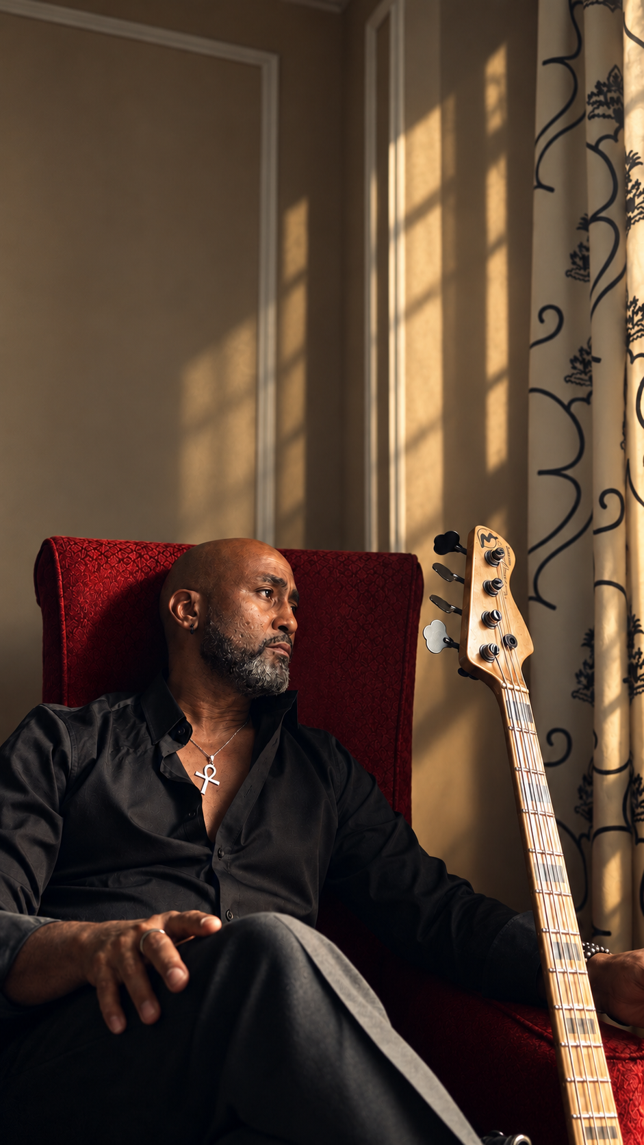 Ted Gould III seated in a red chair with his bass