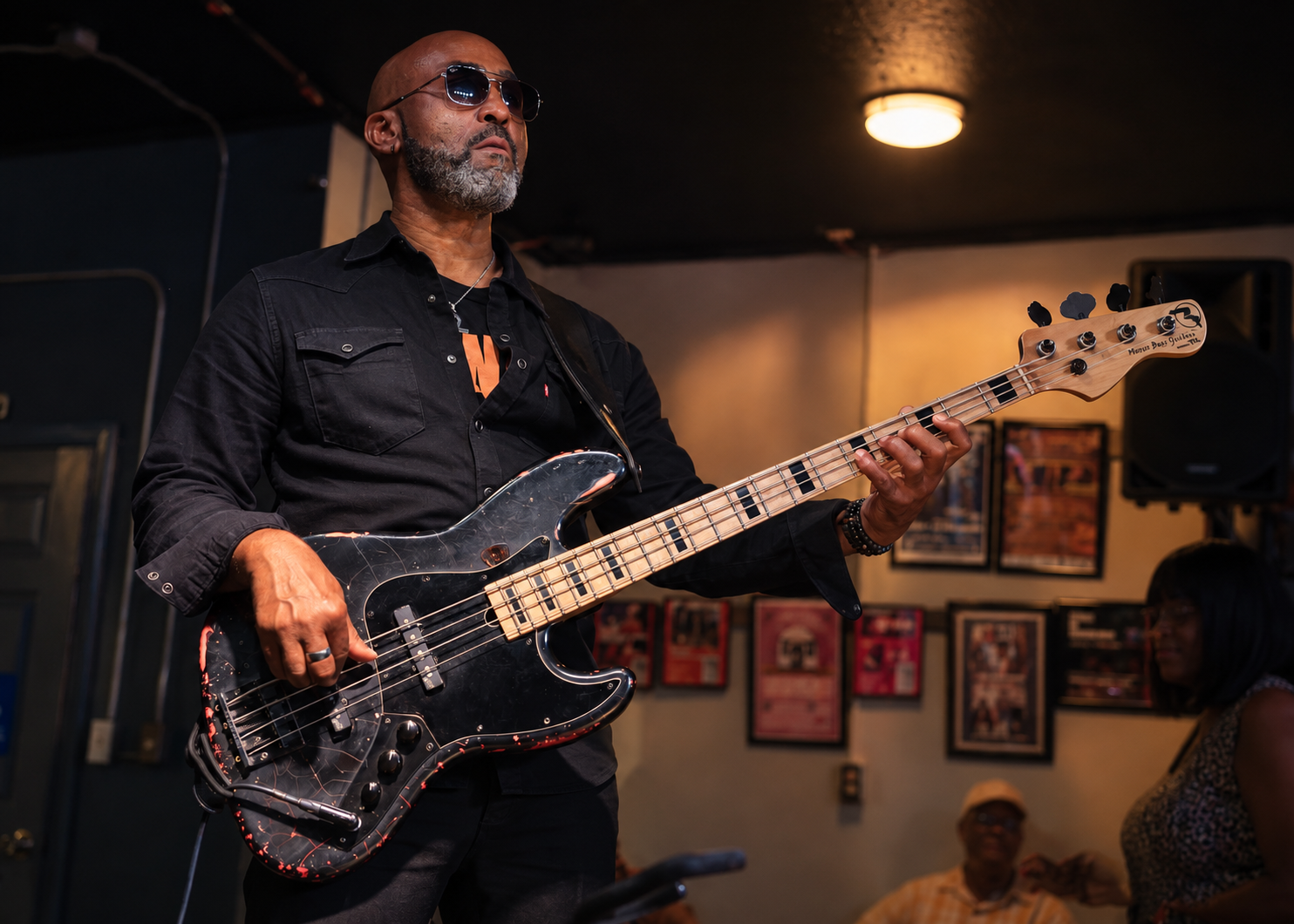 Ted Gould III playing bass in a club, audience behind him