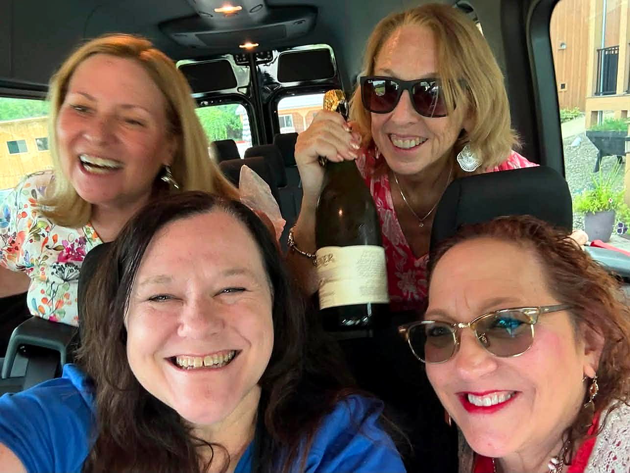 Wine Campers laughing together on the bus between winery visits