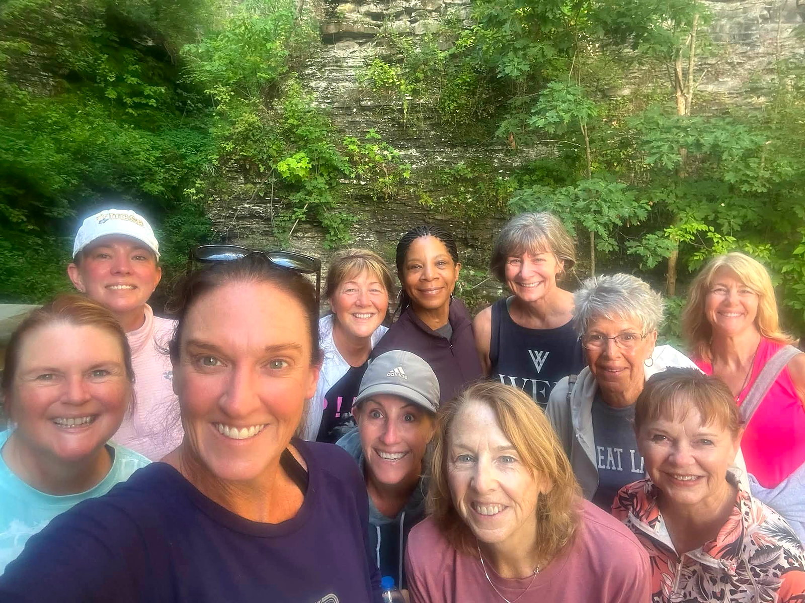 Wine Campers gathered beside a waterfall during the Watkins Glen Gorge hike