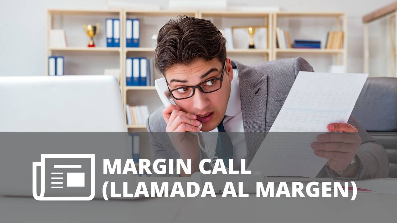 Inversionista preocupado hablando por teléfono mientras revisa un documento frente a su computadora, representando una llamada al margen o margin call.