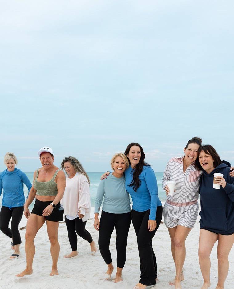 Retreat women laughing and walking on the beach