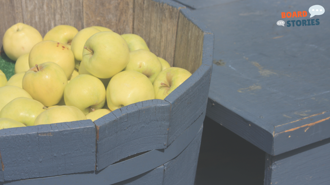 Close-up photograph of yellow-green apples piled in a rustic blue wooden barrel, with an empty barrel visible beside it against a weathered wood backdrop, with the Board Stories logo in the upper right corner. The image illustrates the newsletter's theme that boards are not a barrel of apples — one bad director does not spoil the bunch.