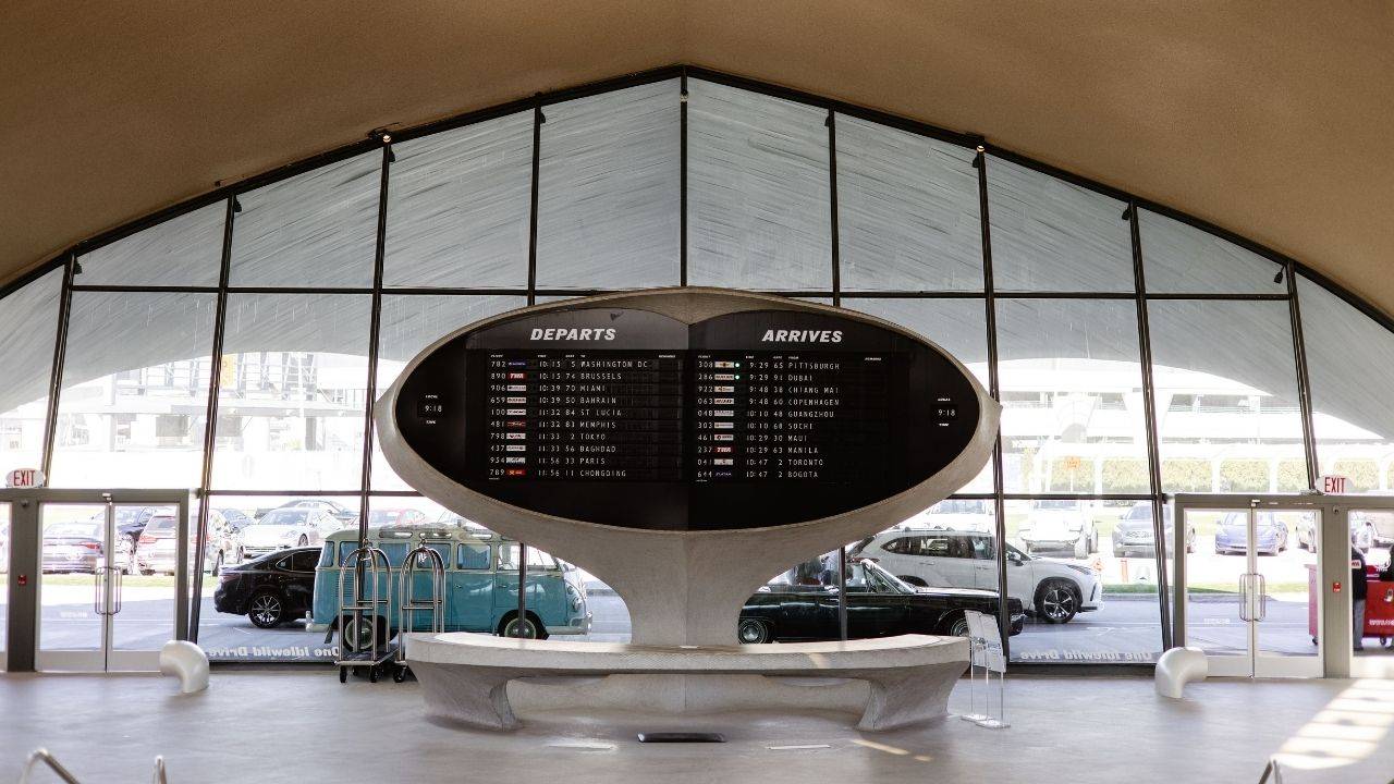 Airport terminal sign showing departures and arrivals above a seating area. Photo by Josh Withers on Pexels