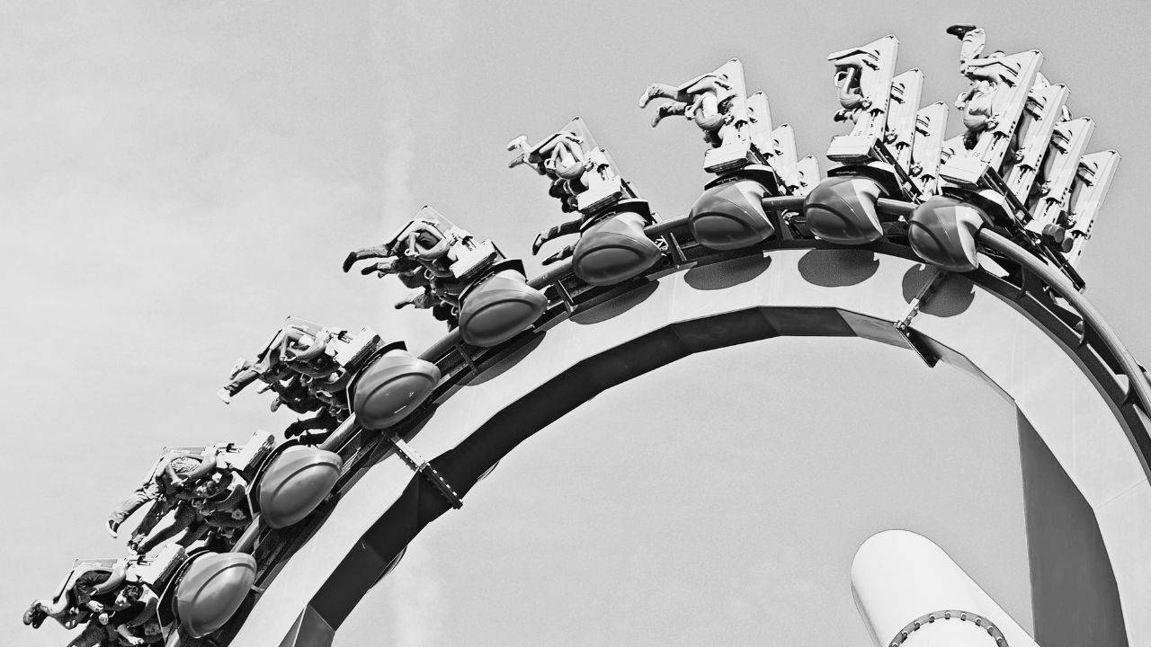 Roller coaster cresting a steep curve, illustrating the repeated organizational flattening and rebuilding of management layers. Photo by: Christopher Yarzab via Pexels