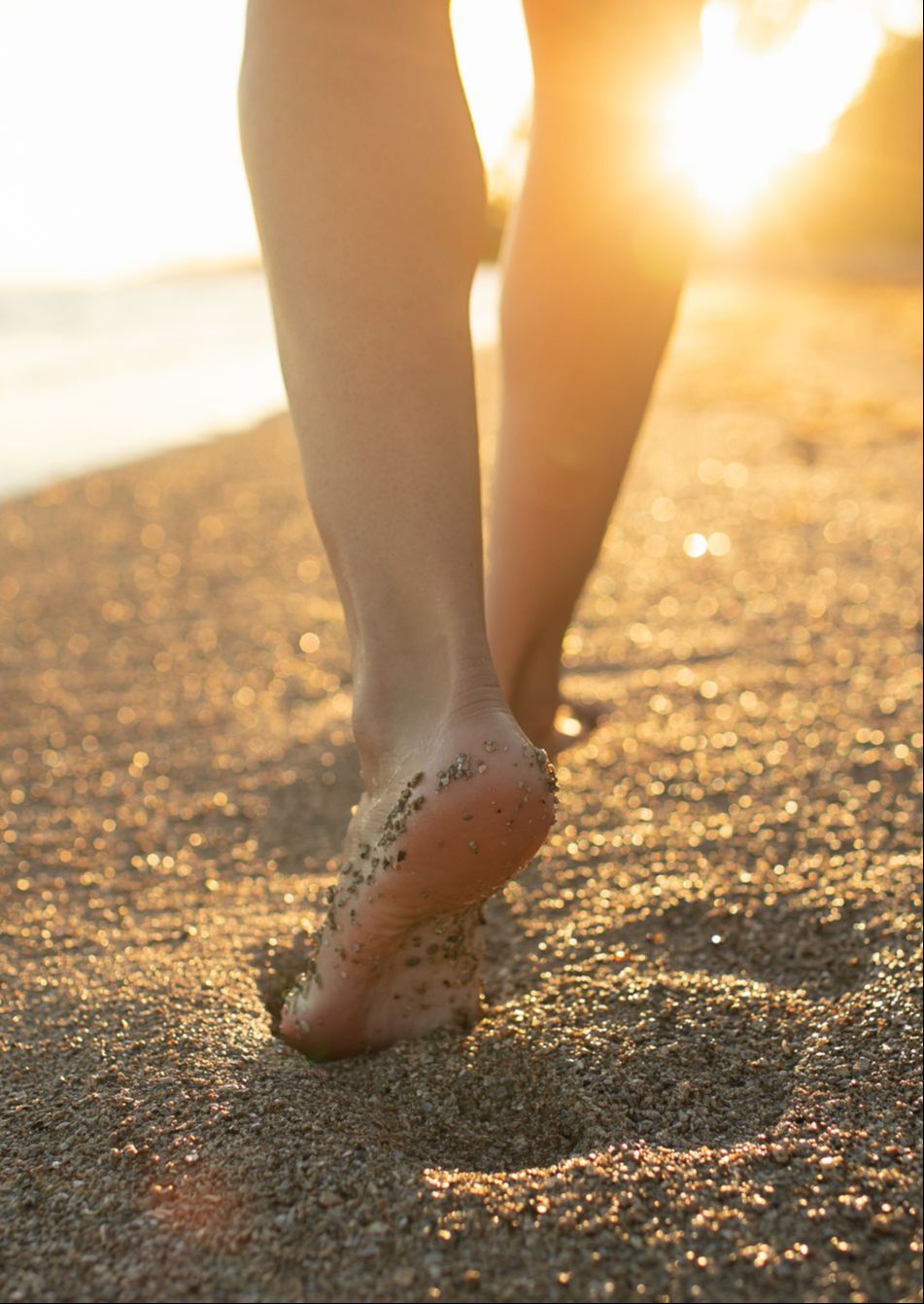 Foot Walking on beach with sunlight