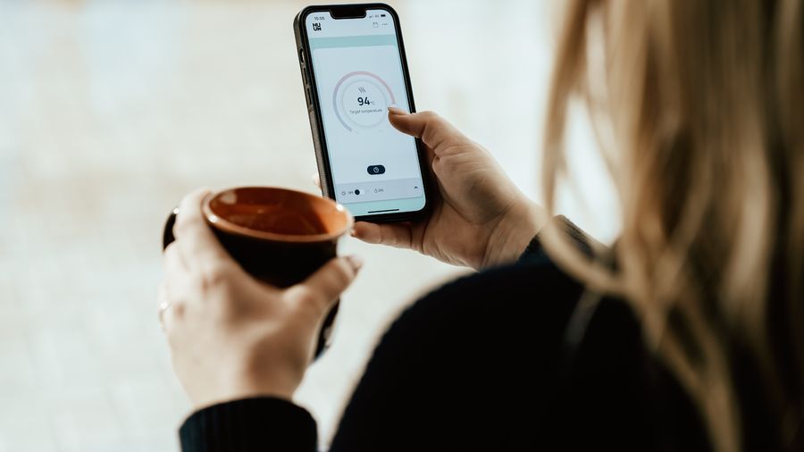 A woman closing a meditation app on her phone and taking a deep breath, symbolizing choosing presence over productivity hacks.