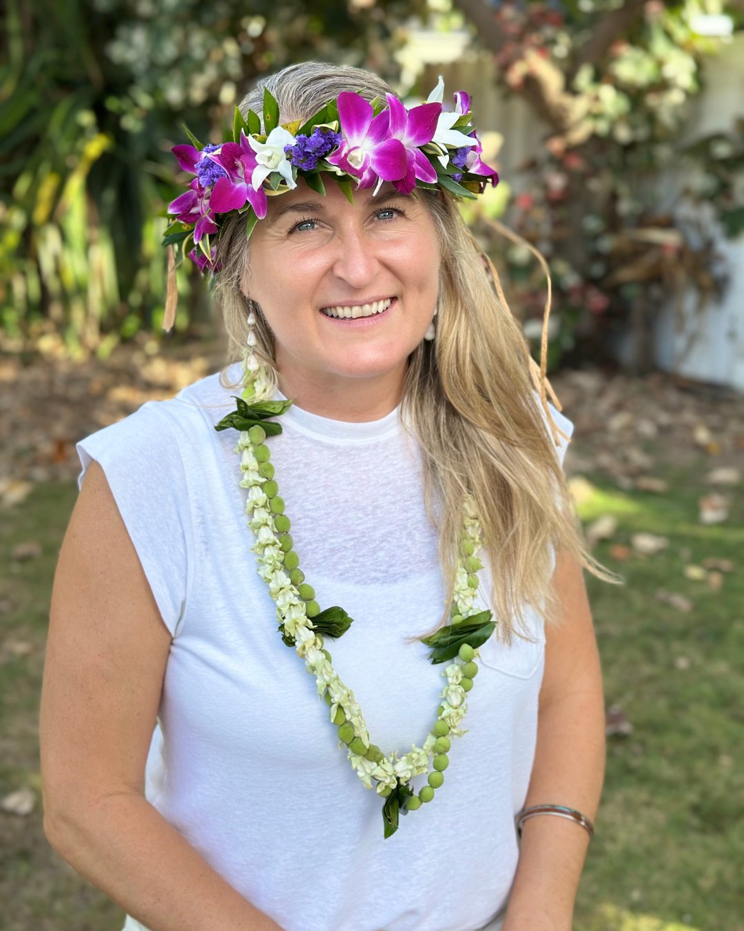 Amber Bodily smiling, wearing a flower crown and lei