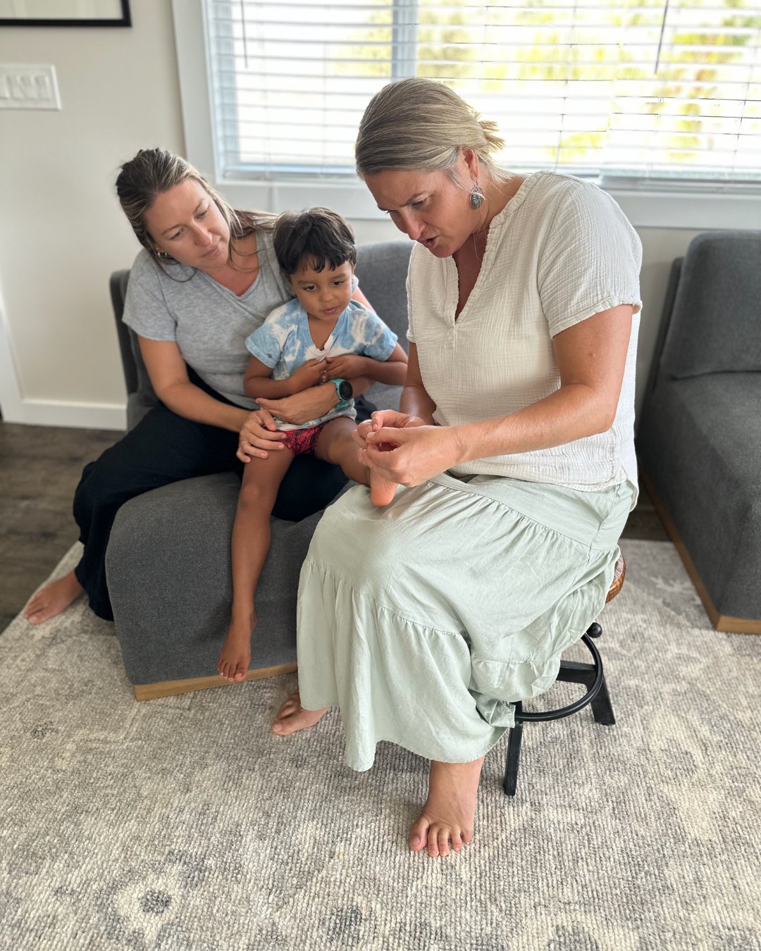 Amber reading a young child's foot