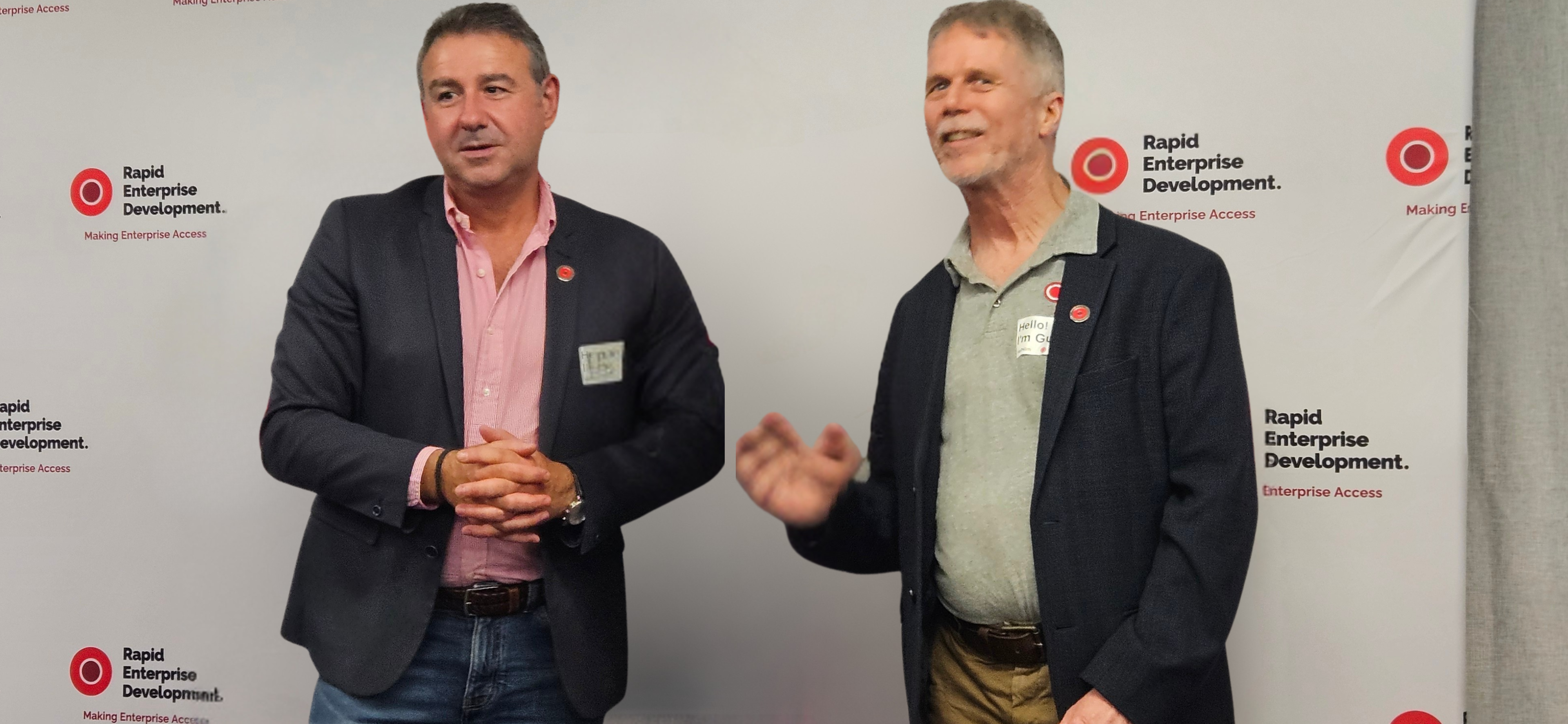 Two people stand in front of a branded backdrop for Rapid Enterprise Development at a professional event.