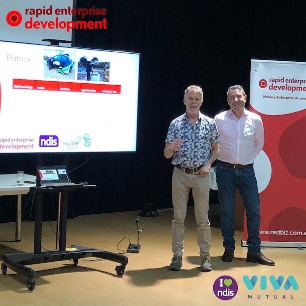Two presenters stand beside a screen showing a 'Patrick' slide with logos for Rapid Enterprise Development, NDIS, and Health, next to a branded banner reading 'Making Enterprise Accessible' and logos for I ❤️ NDIS and VIVA Mutual.