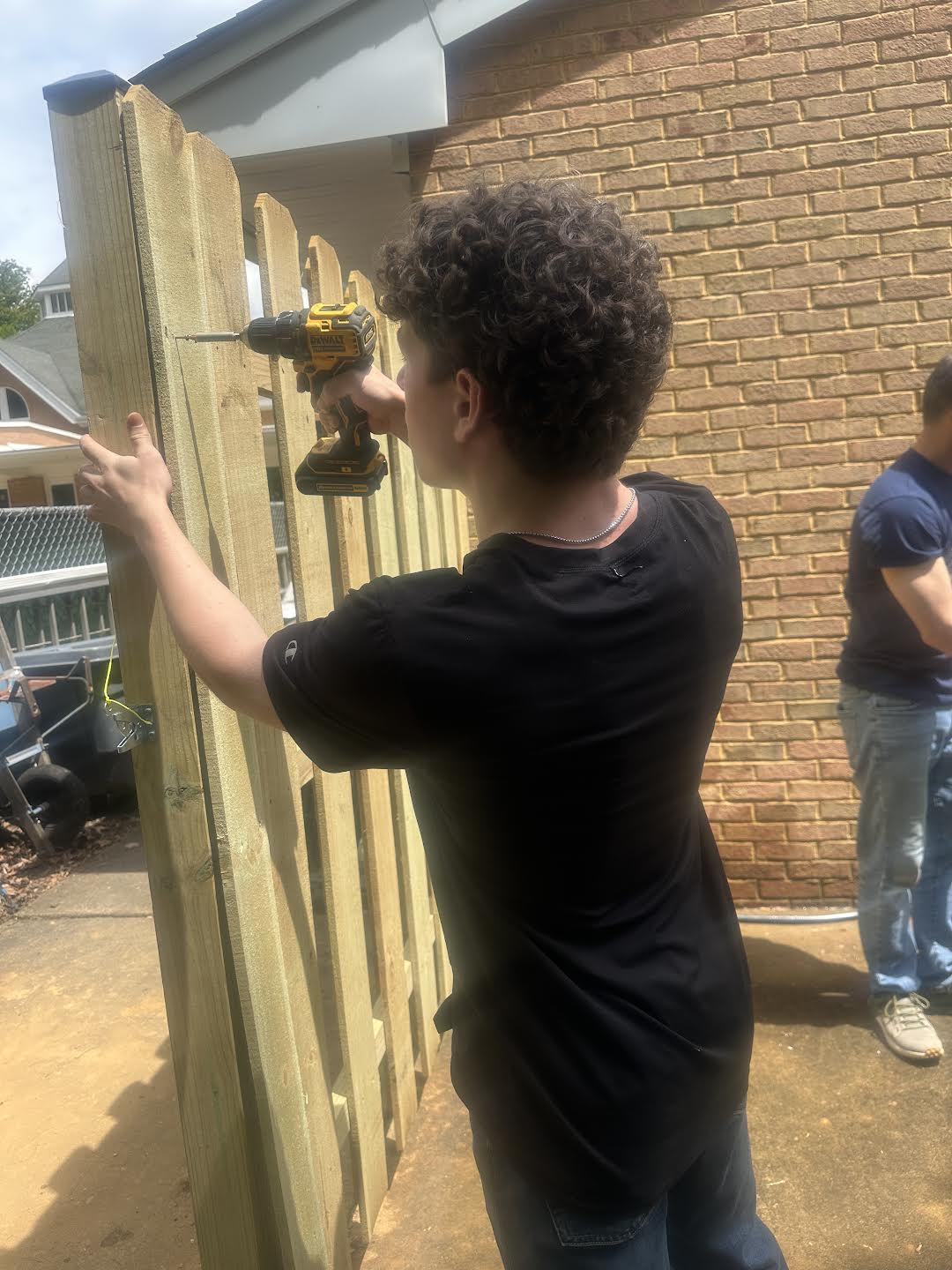 Dean Corso helping build a fence during a youth community service project