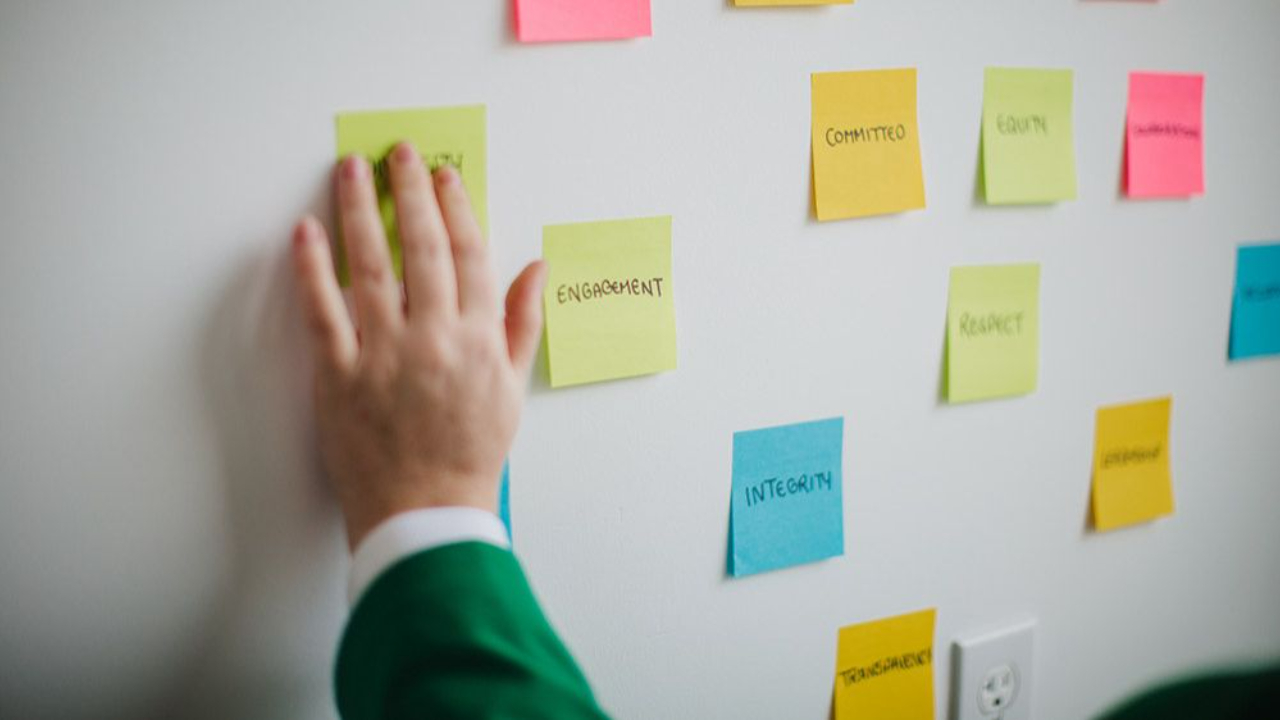 Sticky notes labeled with values and committee ideas arranged on a wall, illustrating how effective governance goes beyond structure through consistent practices and engagement.