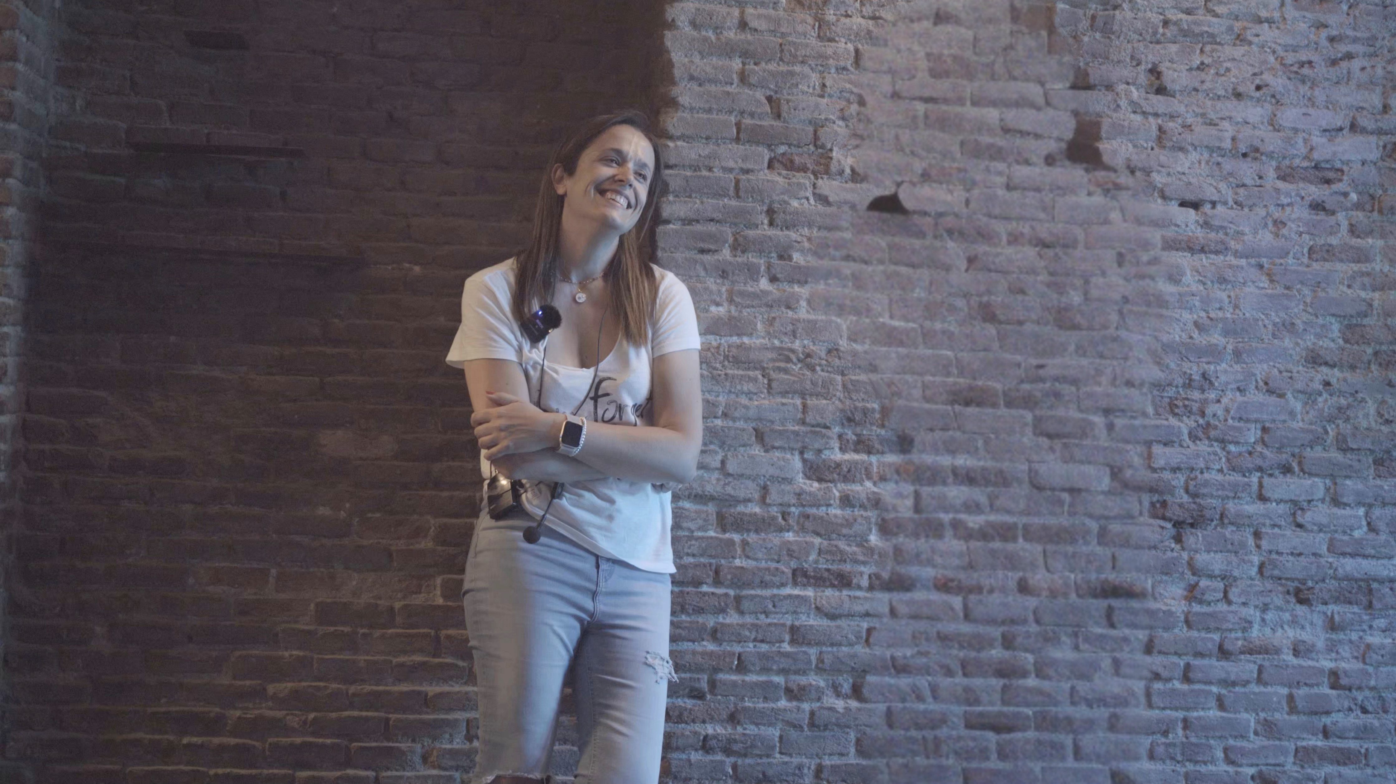 Marta Cea apoyada en una pared de ladrillo