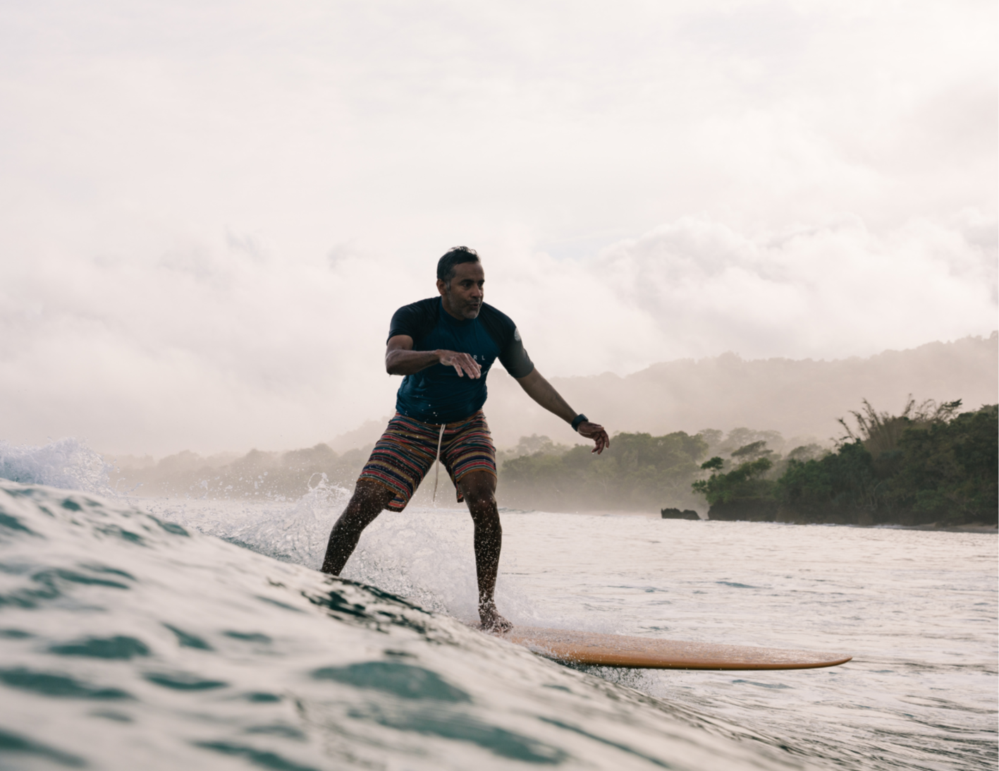 Surfers holding hand and riding a small wave comfortably, surf retreat guest is so happy, cheering and smiling