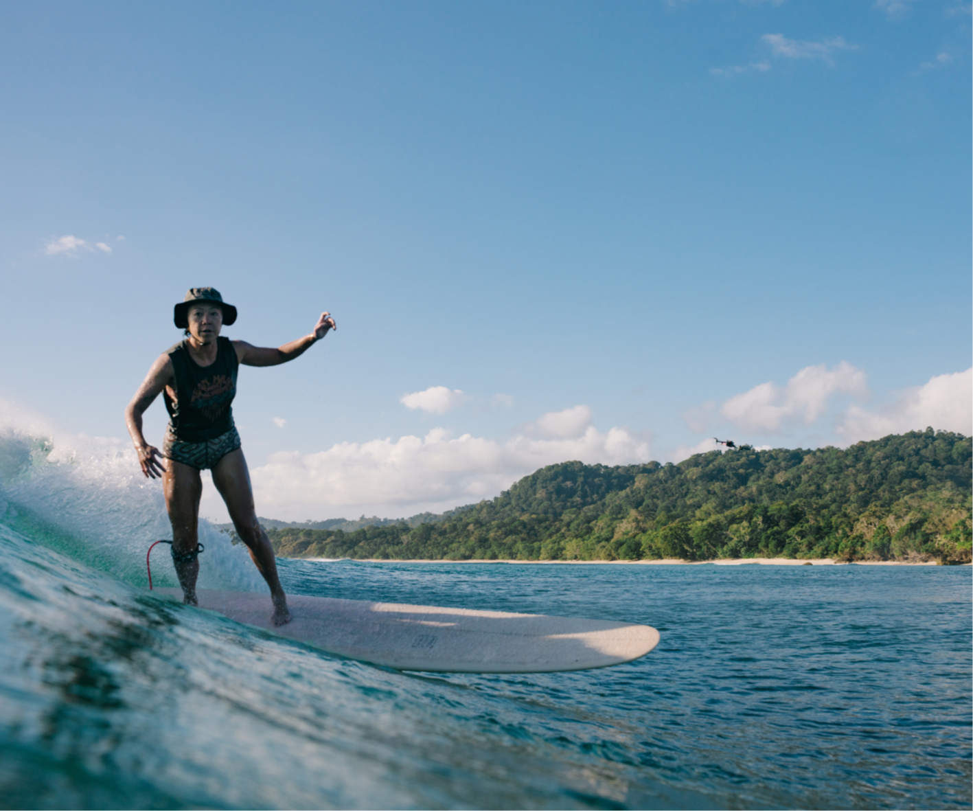 indonesian local surf coach cheering and smiling in the water, surf coaching in lombok for beginners and intermediates