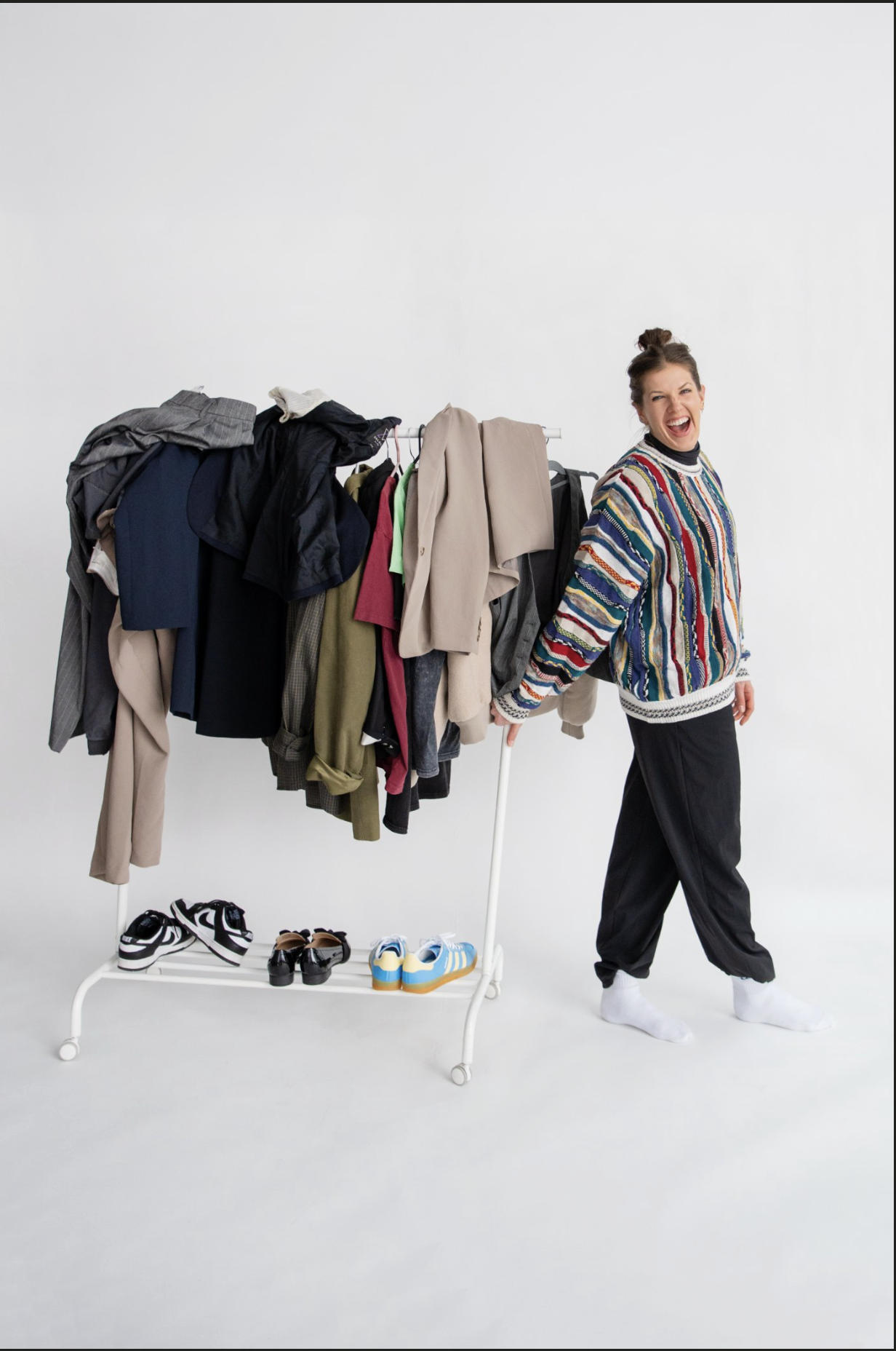 Meg laughing beside a clothing rack