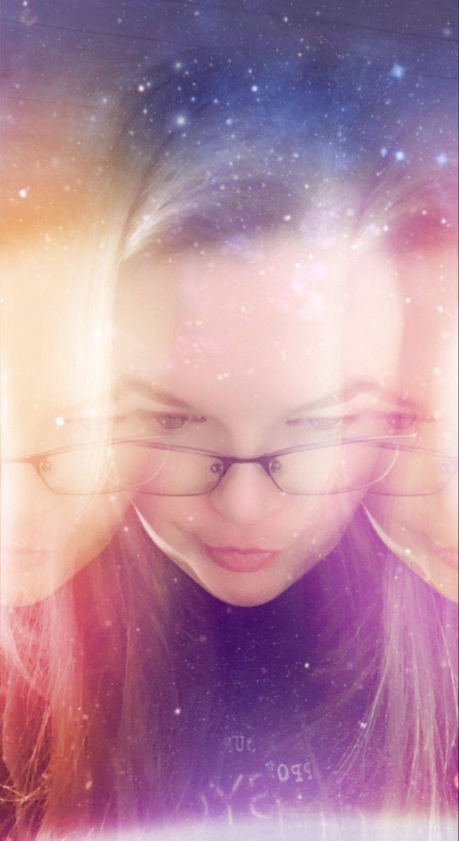 Carissa Andrews looking down over her glasses, overlaid with a field of stars and coloured light