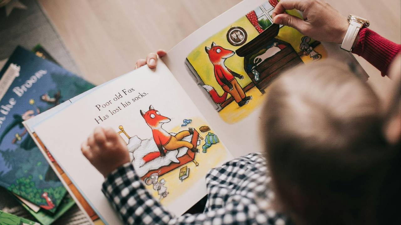 a preschooler playing a phonological awareness game using a storybook