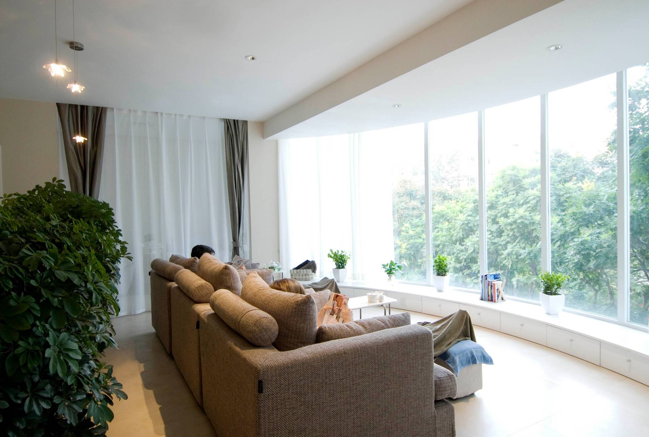Kocoon spa in Beijing showing the lounge area with couches overlooking a big green tree through the window 