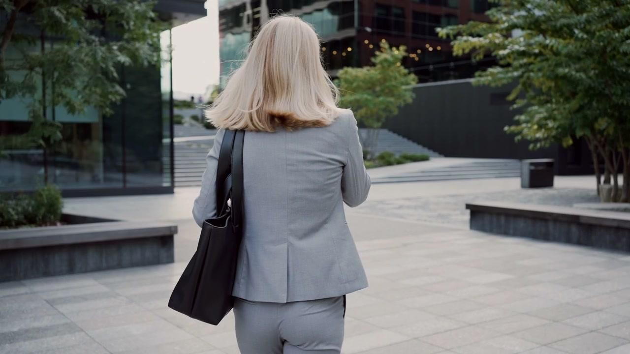 Blonde woman confidently overlooking a city while embracing entrepreneurship and a new career after 45.