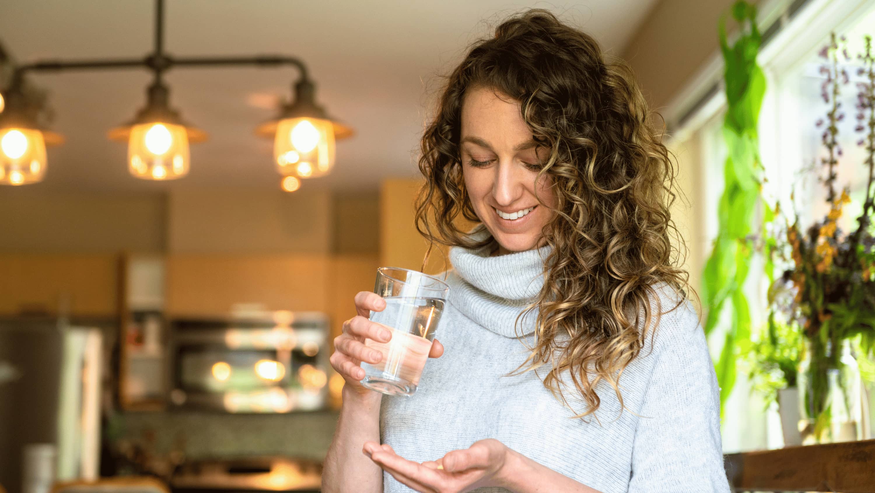 A woman's morning wellness routine — supplements, water, and a calm start to the day