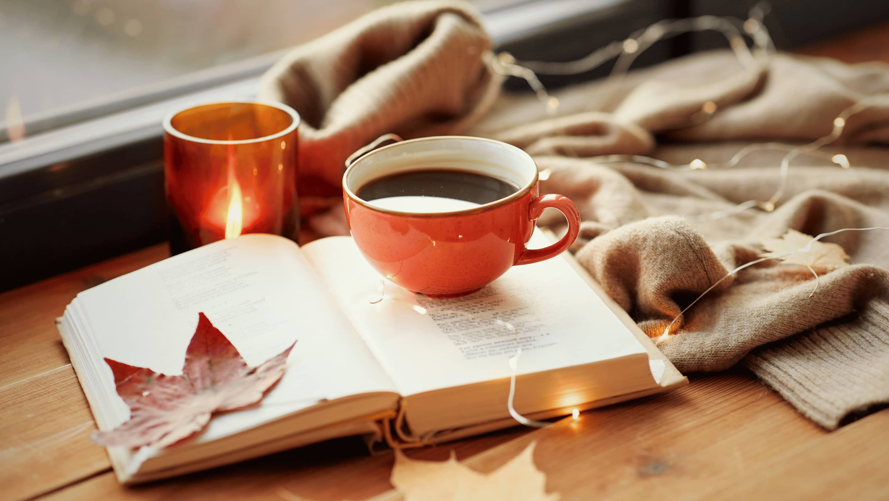 A warm mug of tea on a wooden table in soft autumn light — the cosy side of Sober October