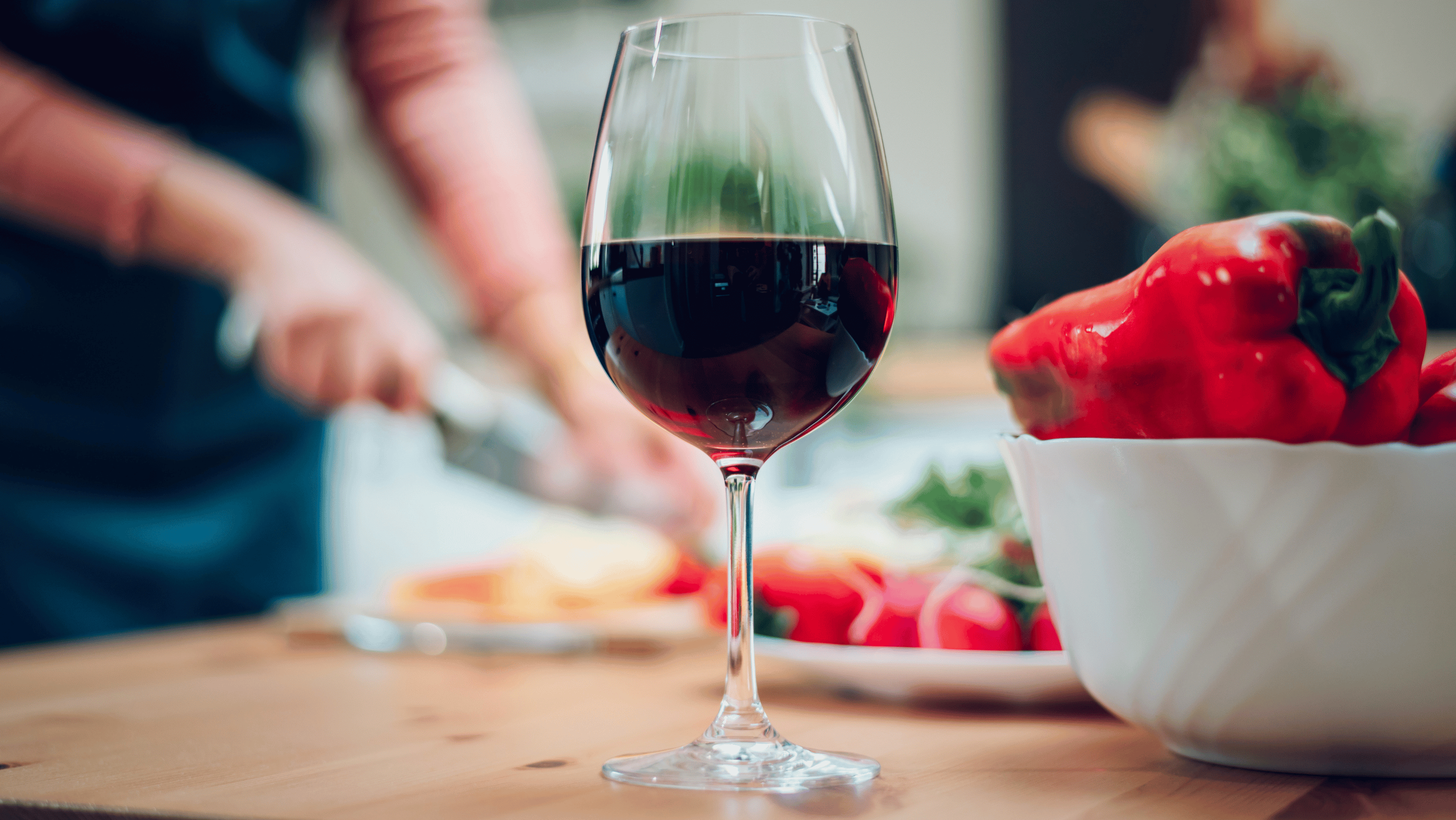 A glass of wine on a kitchen counter in warm evening light — the everyday drinking pattern and its effect on weight, sleep and appetite