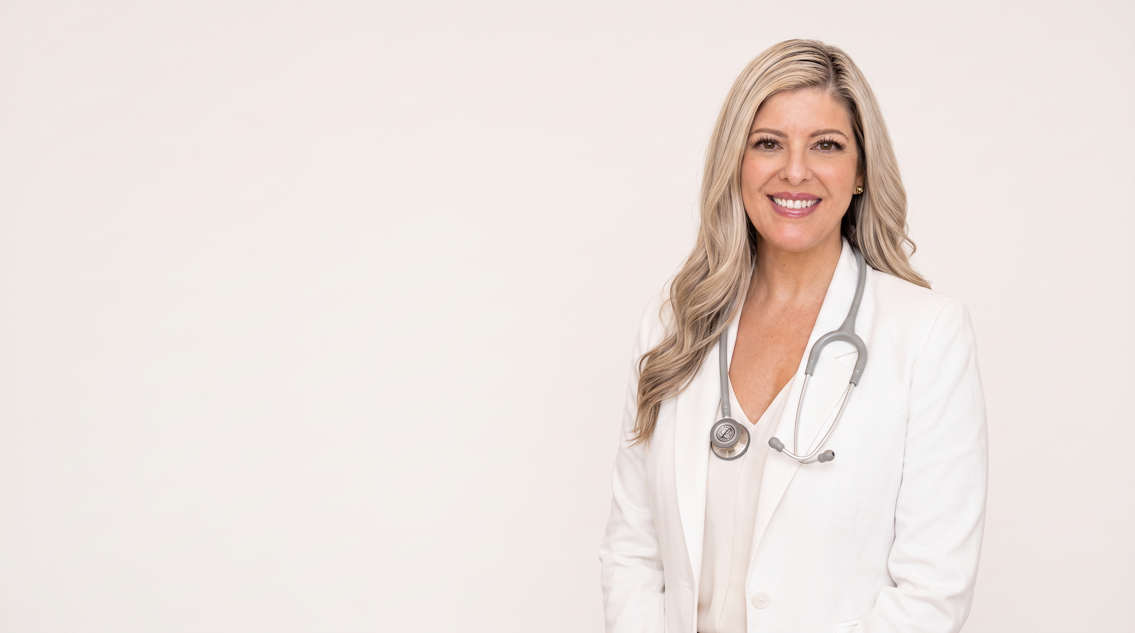 Lindsay Goodwin, founder of Fertile Frequencies, wearing a white blazer and stethoscope