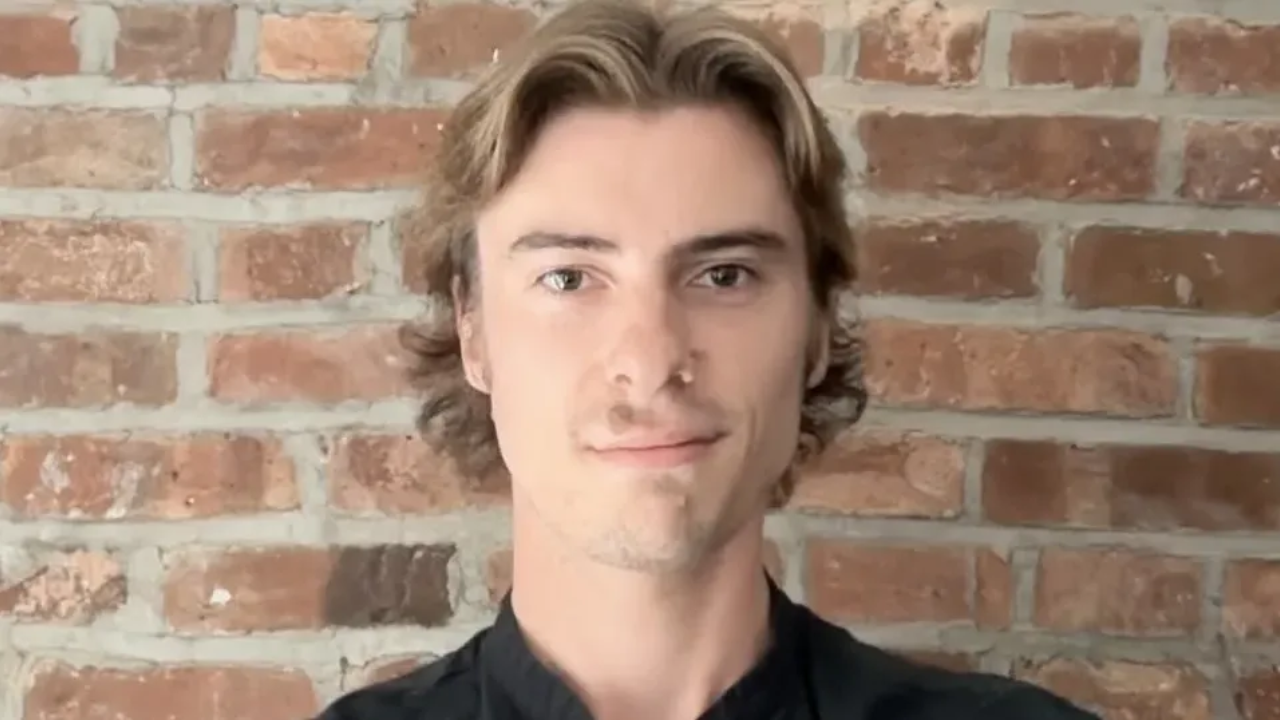 Tyler, a Maestro Music piano teacher, smiling in front of a brick wall