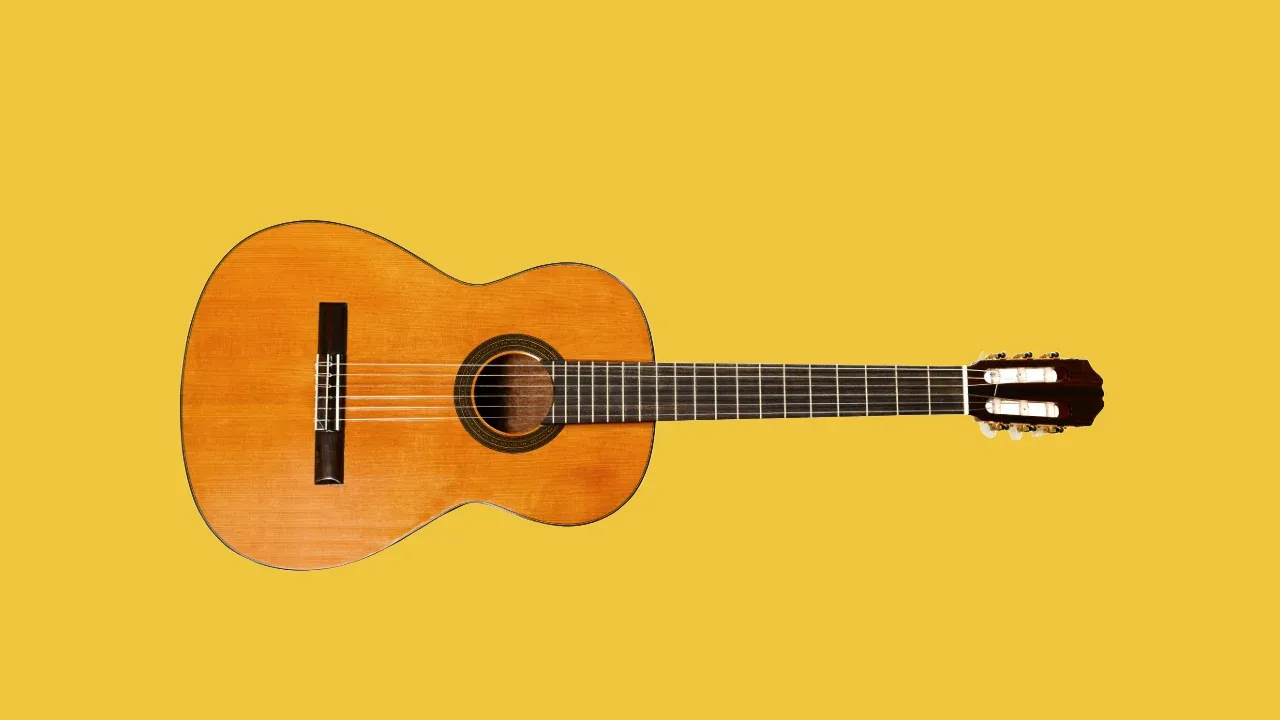 Classical acoustic guitar on yellow background