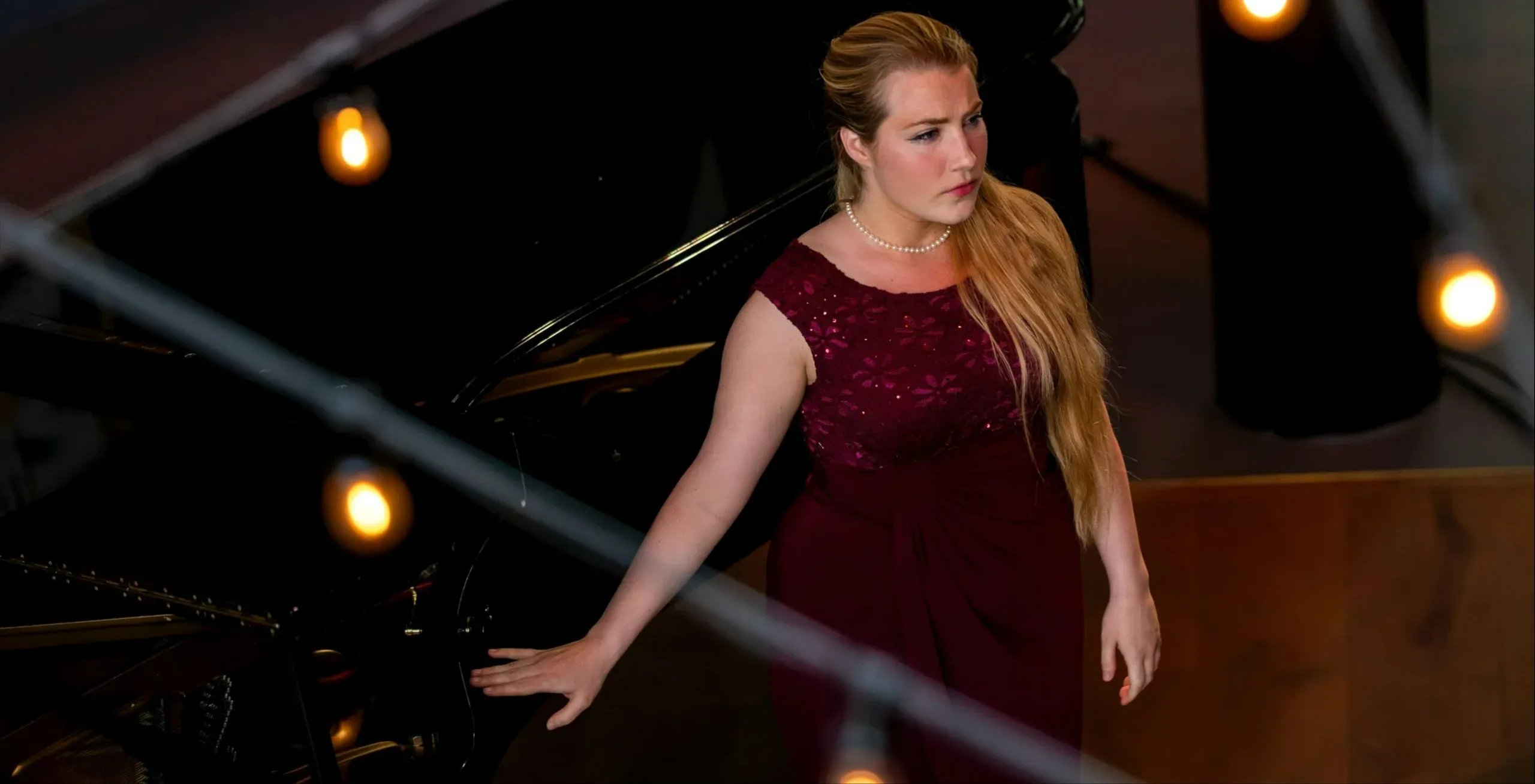 Online piano teacher and opera performer, Olivia, looks focused while preparing to step on stage for a singing performance
