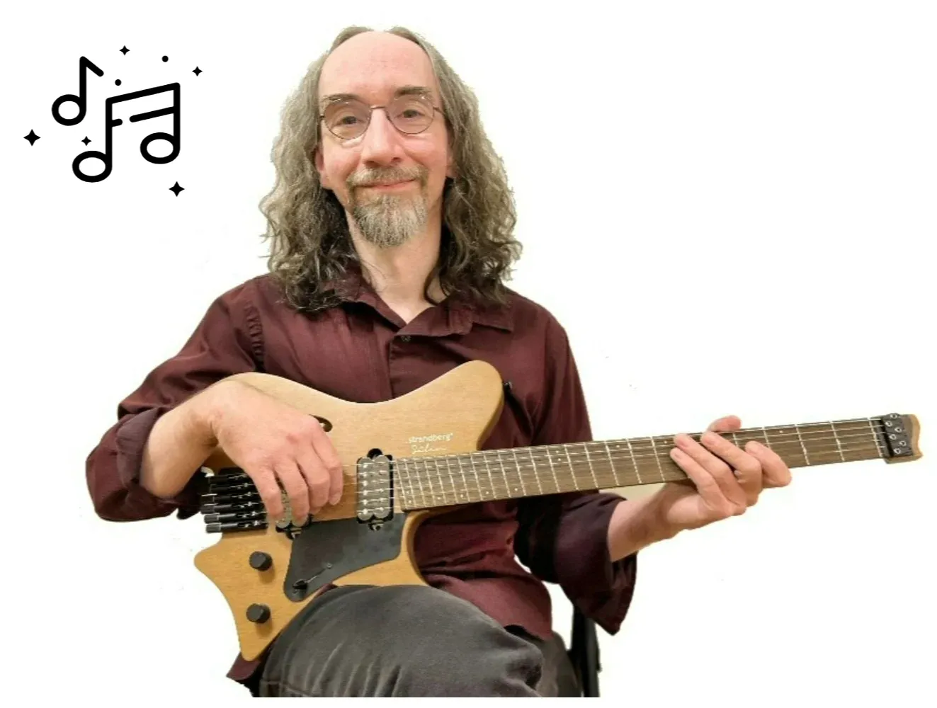 Andre smiles at the camera while holding his guitar with drawings of music notes around him