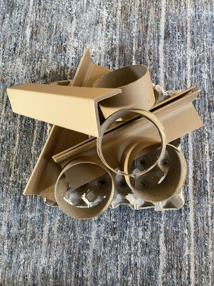 A pile of cardboard tubes, corner pieces and an egg carton: loose parts found around the house