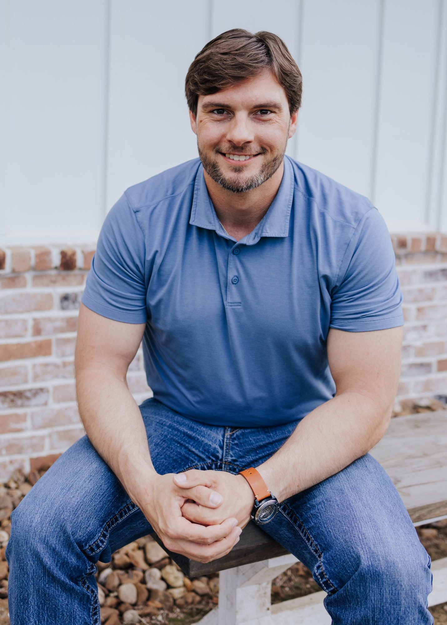 Chase smiling as he sits on an outdoor bench