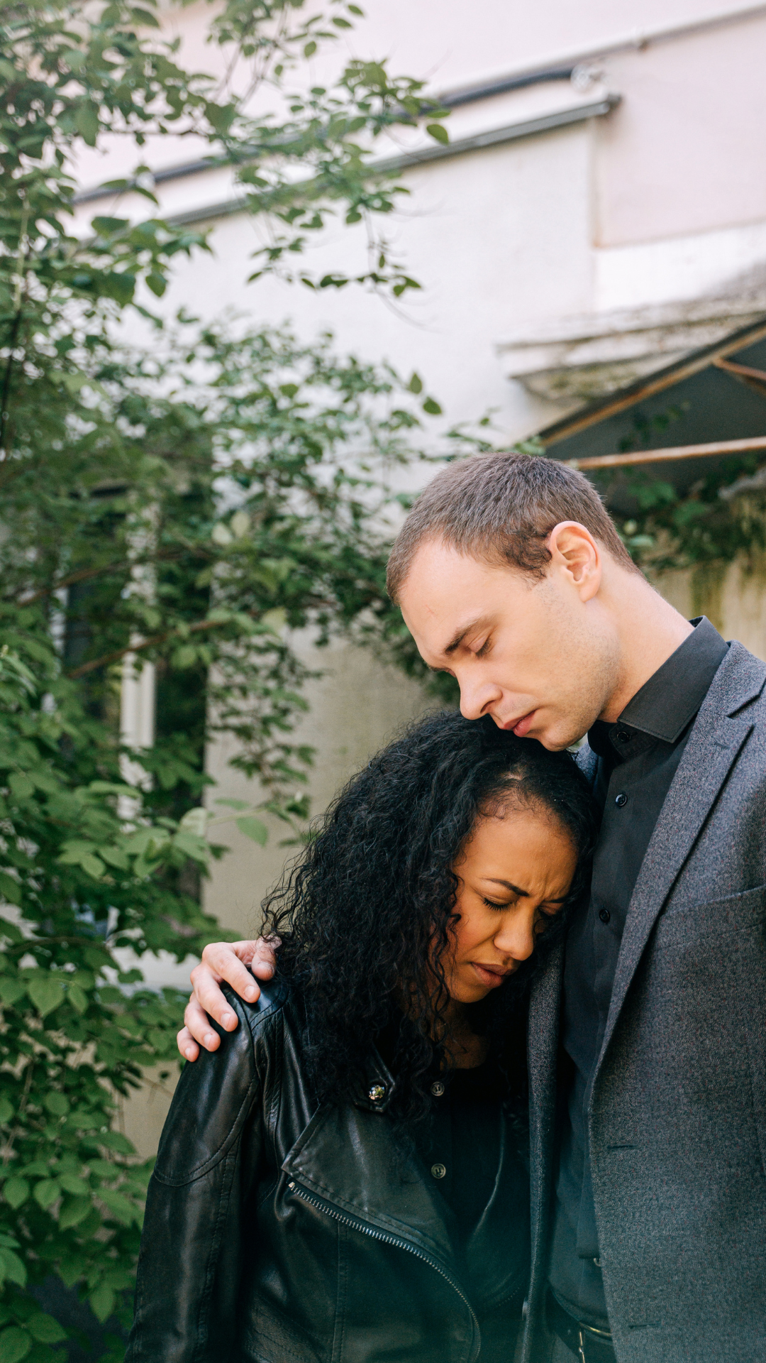 A man comforting a woman resting her head on his chest
