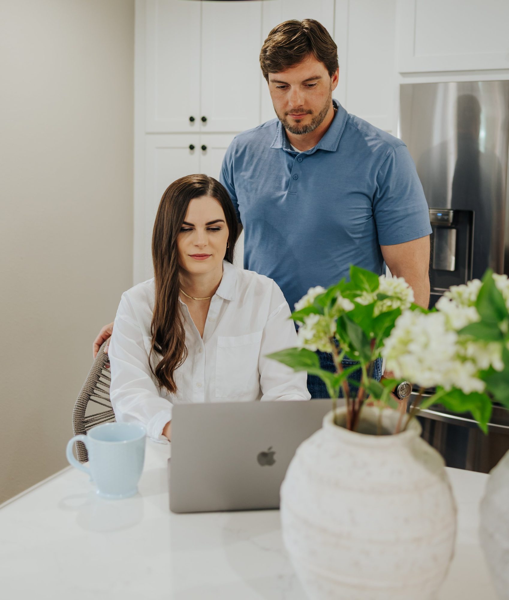 Chase standing behind Katie as she works at her laptop