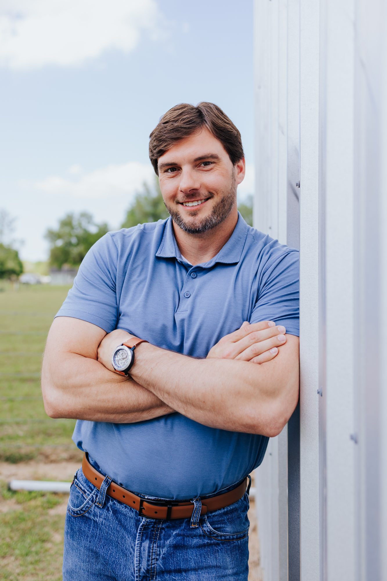 Chase Fayle smiling outdoors with his arms crossed
