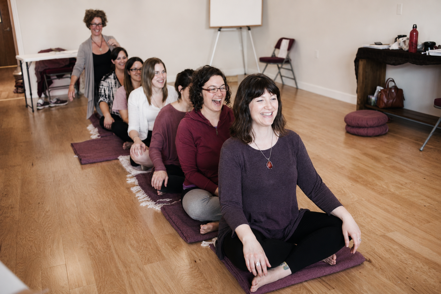 A doula training cohort laughing together during a practice session