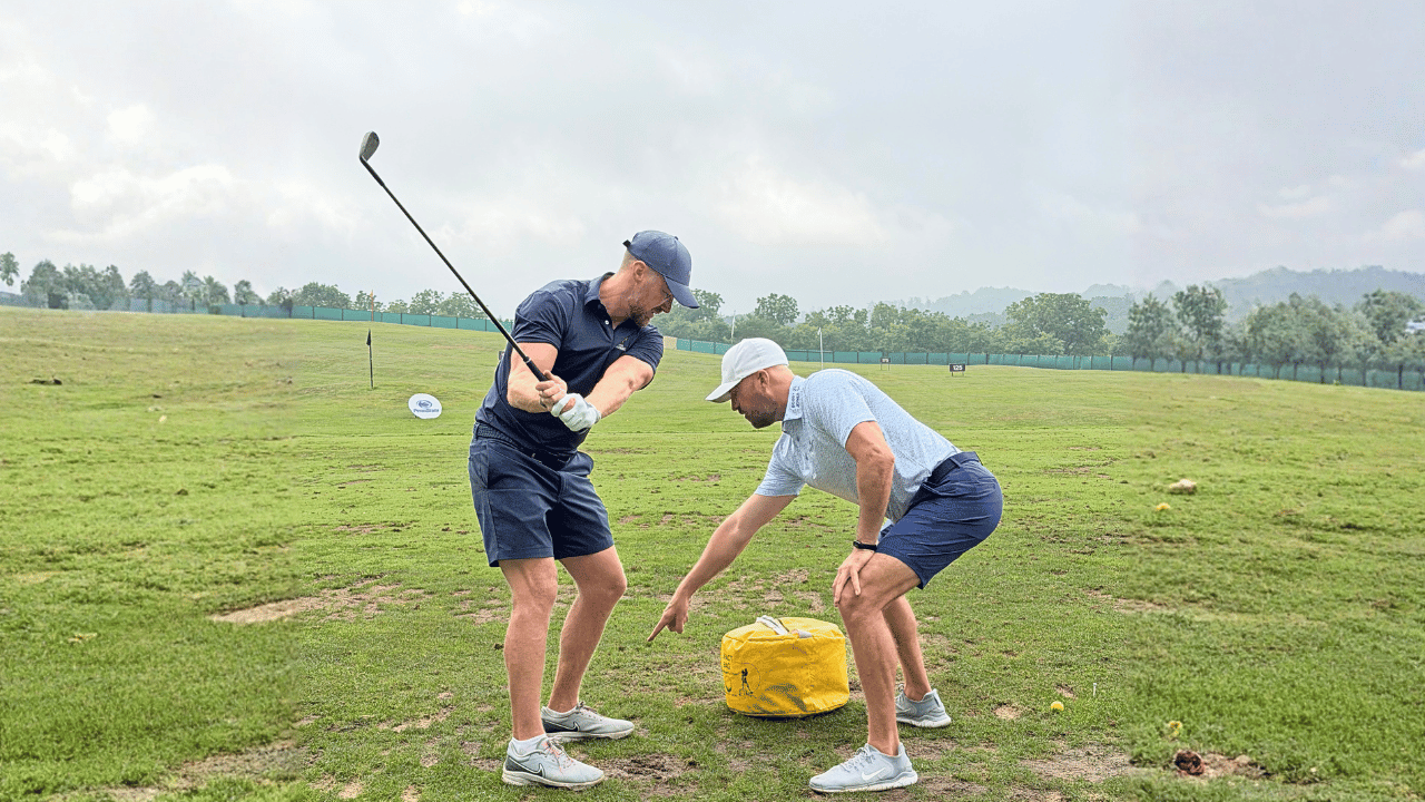 Eric Cogorno teaching a golf school student a full swing drill
