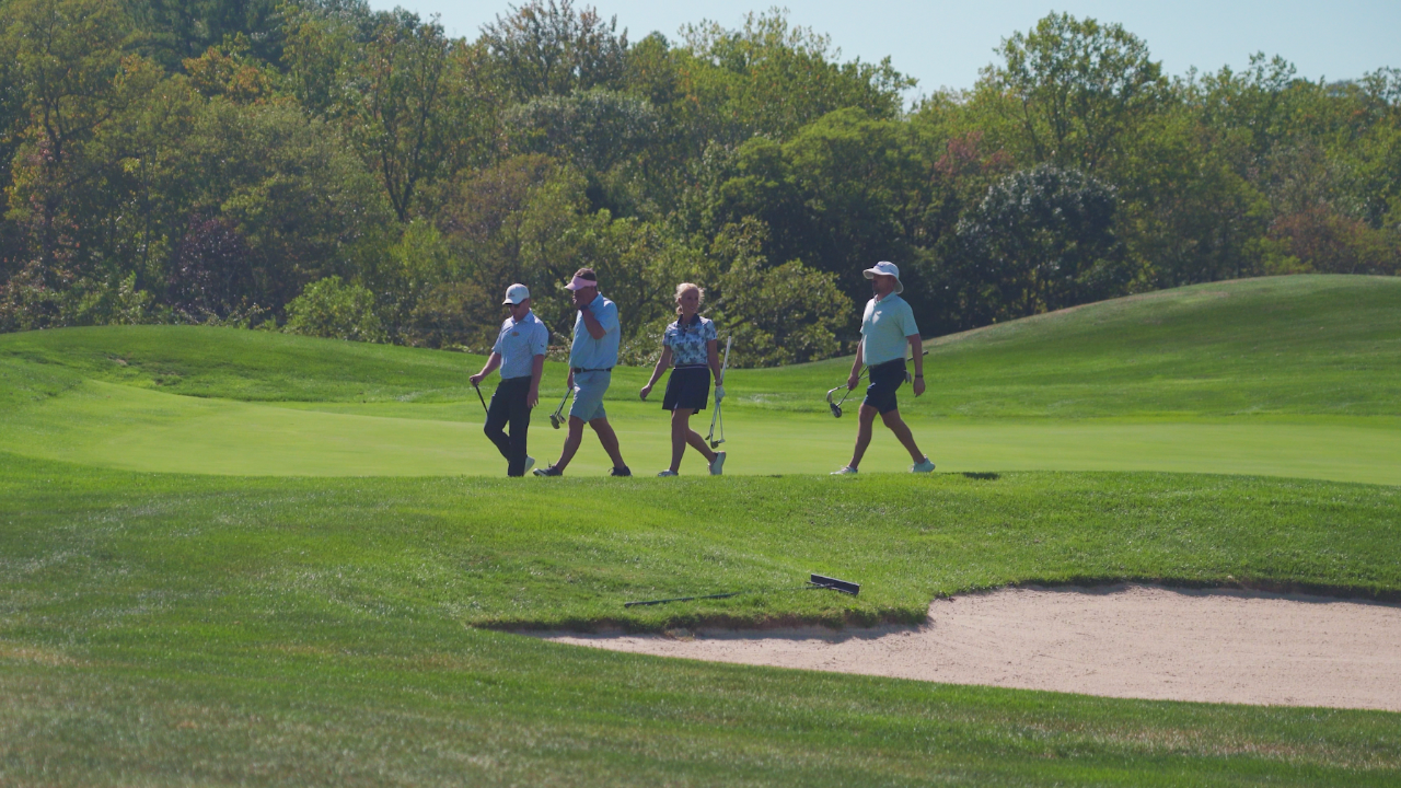 Eric Cogorno walking with golf school students at Woodstone Country Club