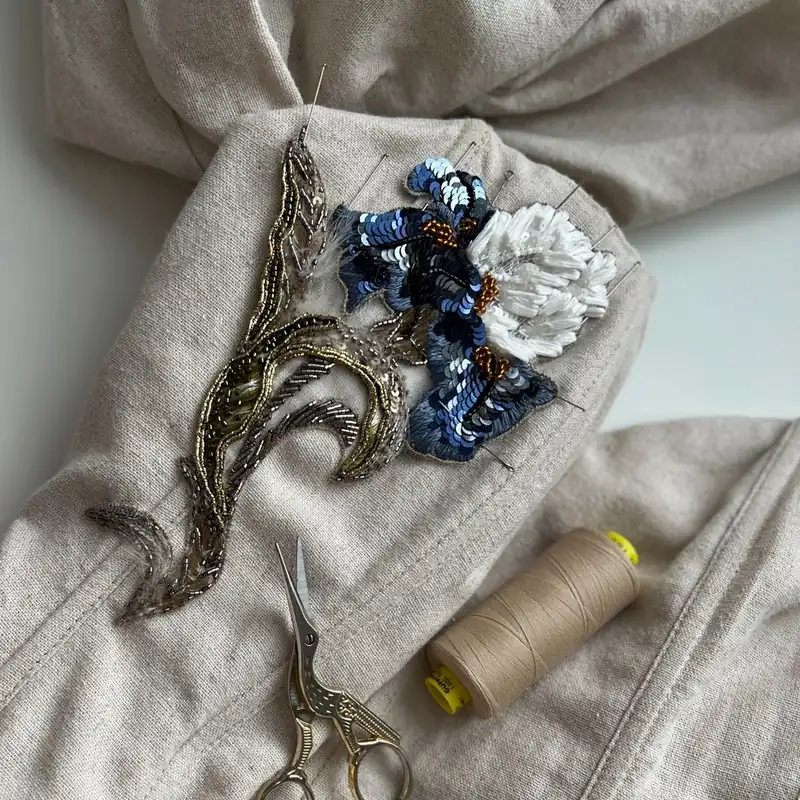 Iris embroidery pinned to fabric with scissors and thread, atelier work in progress, Advanced Level II couture embroidery