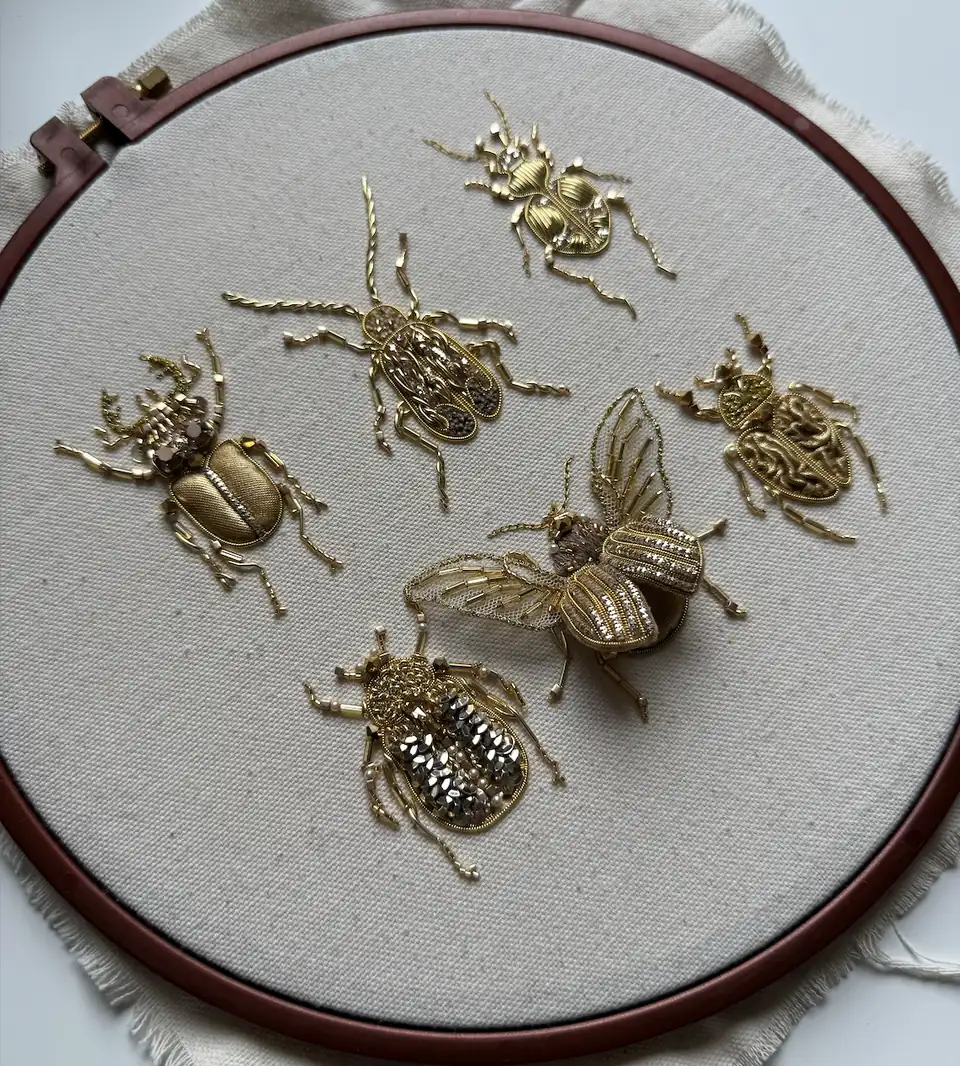 Six golden bug brooches in an embroidery hoop, Golden Bugs goldwork course by Valeria Fic School of Couture