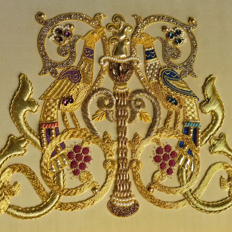 Finished goldwork main project on cream silk with symmetrical birds and gold scrollwork