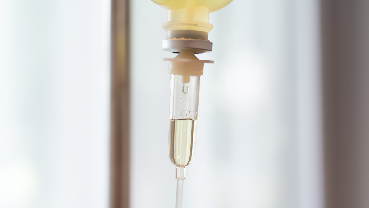 Close-up of an IV therapy drip chamber with nutrient solution, representing IV vitamin therapy protocols for healthcare providers.